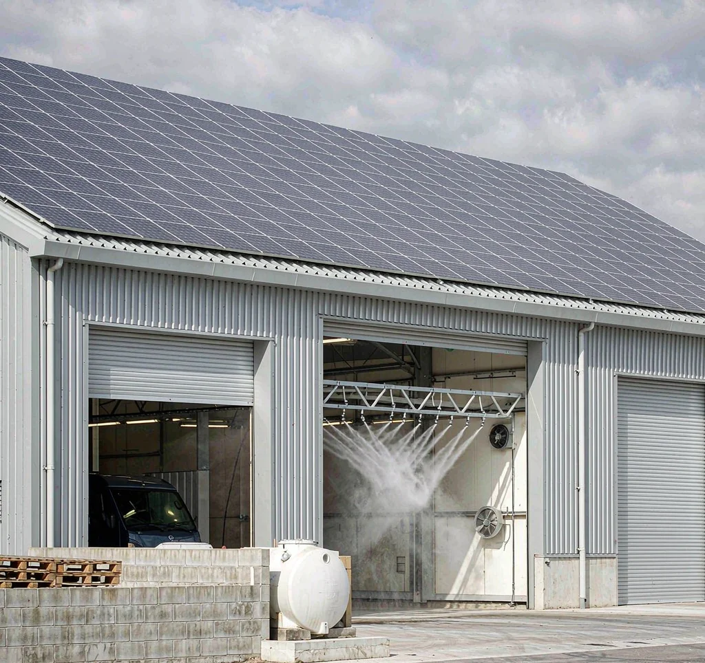 Solar water pump system at a commercial truck and vehicle wash bay with solar panels and water spray