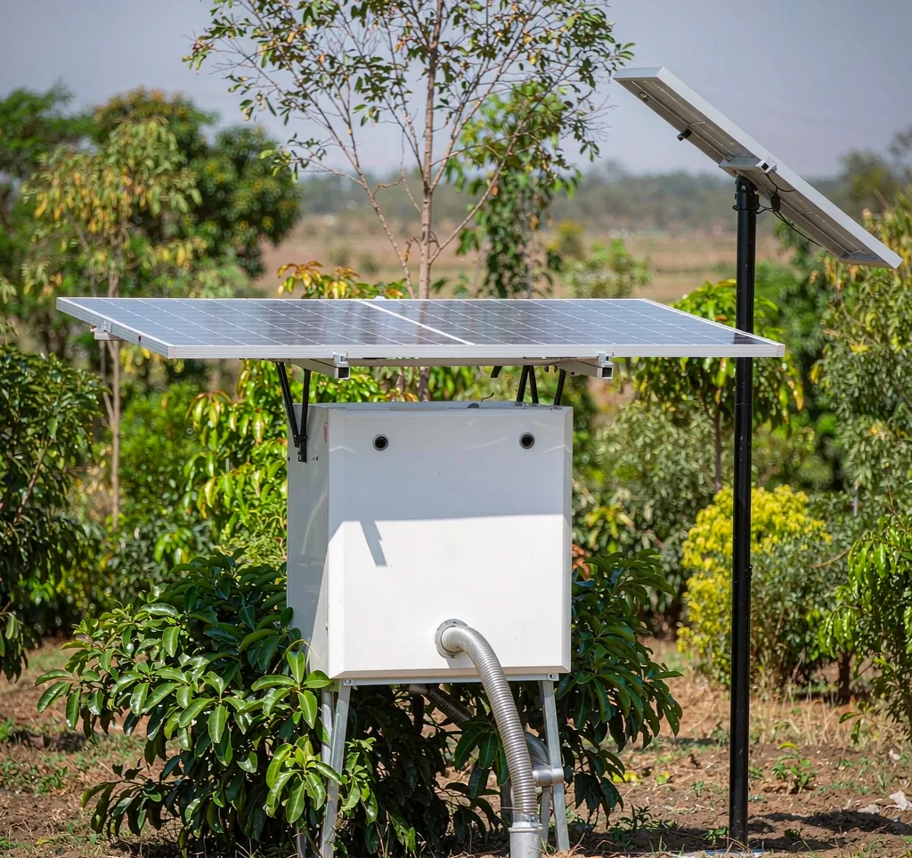 Solar water pump irrigating a smallholder farm field in Africa with solar panel array and green crops