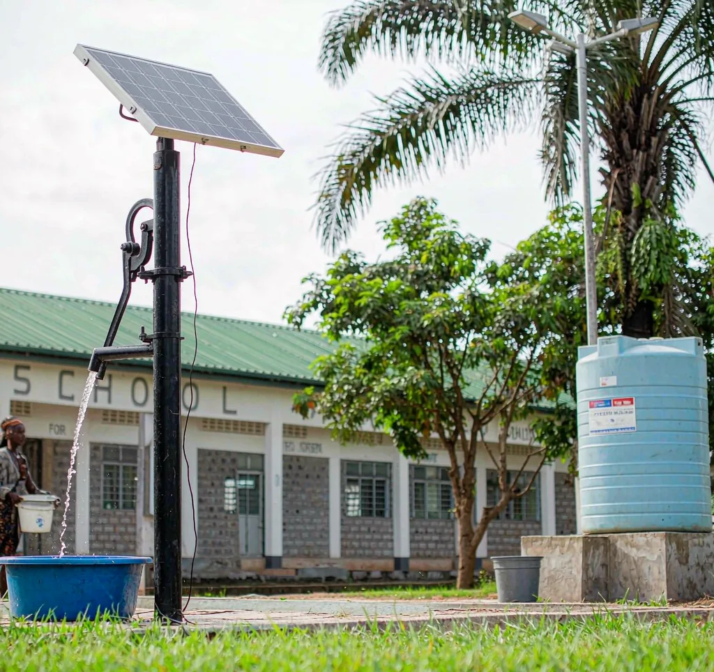 Solar water pump providing clean drinking water at a rural African school with storage tank and panels